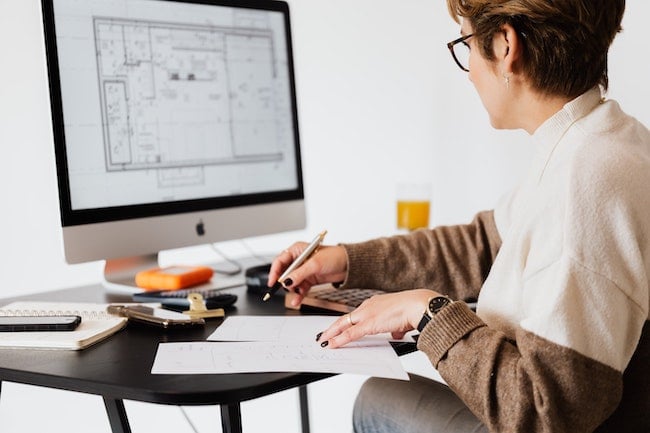 Woman sitting at her desk looking at her construction plans